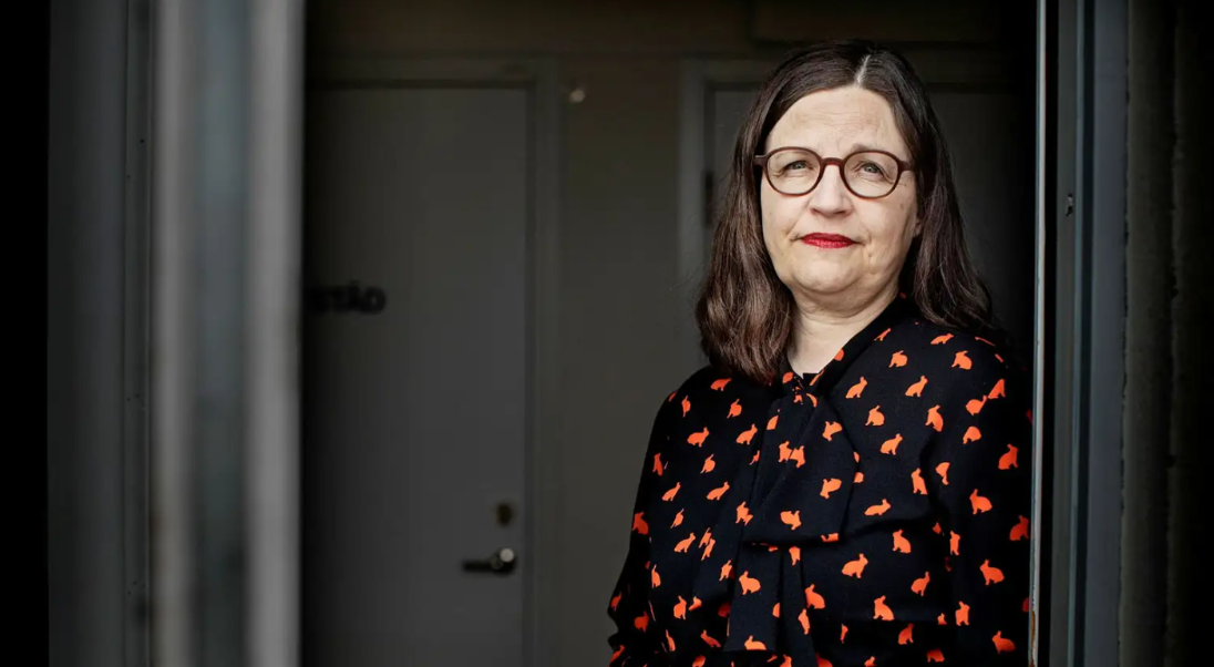 Kvinna med runda glasögon och rött läppstift.