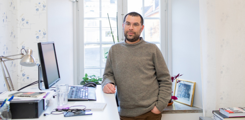 En man står vid ett skrivbord på ett kontor.